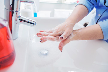 Frau benutzen Seife um Händewaschen unter dem Wasserhahn. Hygienekonzept Hand Detail.cor

