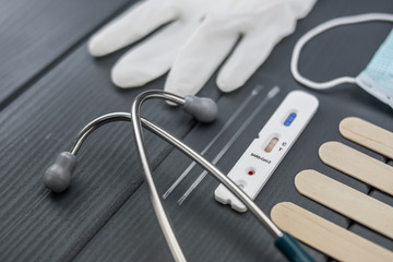 Negative test for coronavirus or covid-19 detection, with stethoscope, gloves and face protection mask on gray wooden background