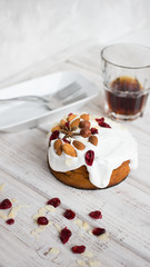 Cake with white cream, almonds and hazelnuts on a dark background. Sweet food. Sweet dessert.