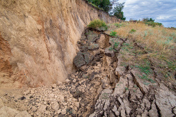 ecological disaster landslide of clay soil after an earthquake, a close up of earth cracks with dry...
