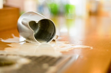 Barista's job. pitcher with spilled milk on the table. cappuccino