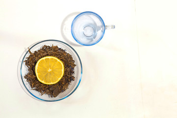 dry tea leaf and lemon on a white background