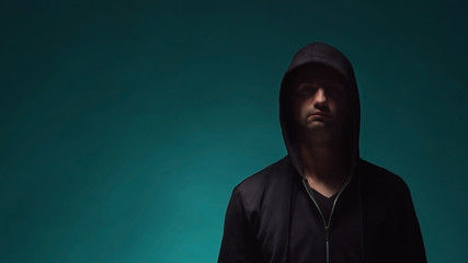 Portrait of computer hacker in hoodie. Obscured dark face. Data thief, internet fraud, darknet and cyber security .