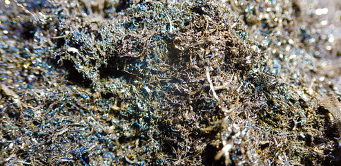 A pile of steel shavings in a metal container