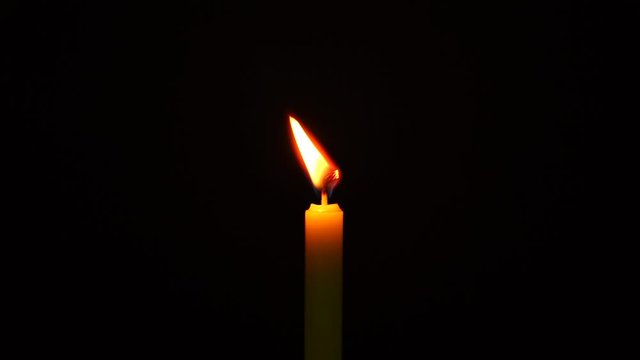 Footage of candlelight in a black background