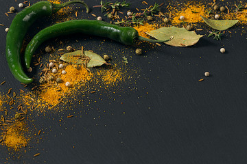 Assorted spices and herbs on dark black background