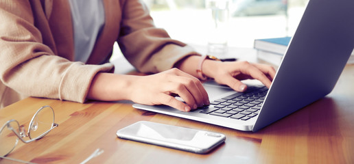 Young woman working on computer at table in office, closeup. Banner design