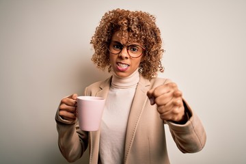 Young african american curly woman drinking mug of coffee over isolated white background annoyed and frustrated shouting with anger, crazy and yelling with raised hand, anger concept