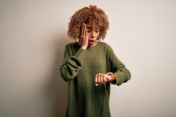 Beautiful african american woman with curly hair wearing casual sweater over white background...