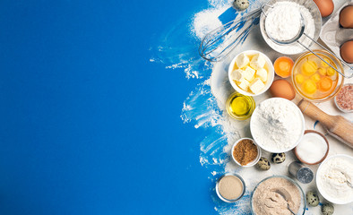 Baking ingredients on blue color background, top view