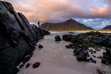 people on the beach, rocks and sand on lofoten islands