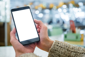 Mock up, white screen, copyspace, template, isolated, technology concept. Mockup image: woman looking at black smartphone mobile device with blank white display at cafe, restaurant - close up view