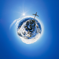 Der Little Planet zeigt die Aussicht vom Karspitz-Gipfel in den Zillertaler Alpen mit Sonnenstern neben dem Gipfelkreuz im Winter.