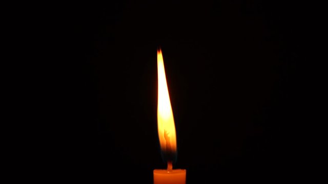 Footage of candlelight in a black background