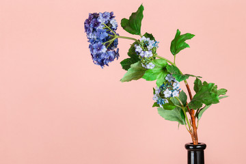 artificial flower in bottle on peach background