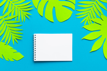Fototapeta na wymiar Concept hello summer. Notepad on palm tree leaves. Paper art. Top view background. Flat lay. copyspace. Empty.