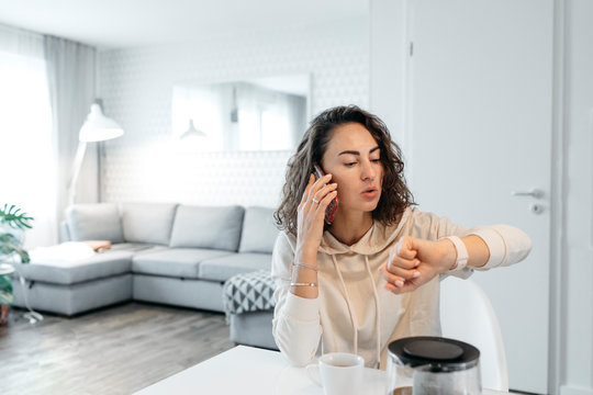 Portrait of woman looking at her smartwatch at home