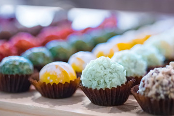 Assortment of colorful delicious fresh truffle cakes for sale on counter of shop, grocery, market, cafe or bakery - close up view. Dessert, sweet food and confectionery concept