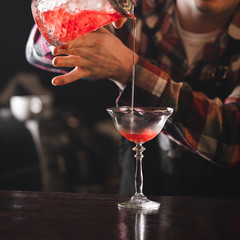 bartender is preparing classic manhattan cocktail
