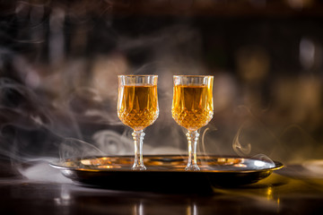 Bourbon in glasses on the bar with a bottle in the background
