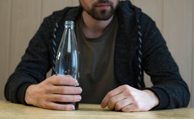 Bottle with dark beer in a man's hand