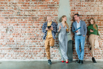 Team of people in startup company standing on brick wall