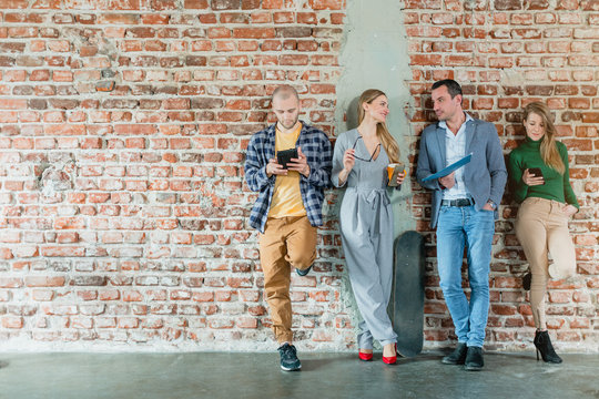 Team Of People In Startup Company Standing On Brick Wall