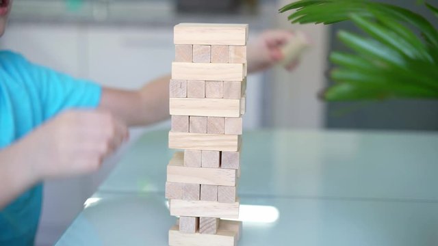 Little boy playing with wooden eco-friendly board game. Concept. Quarantined home games. Indoor