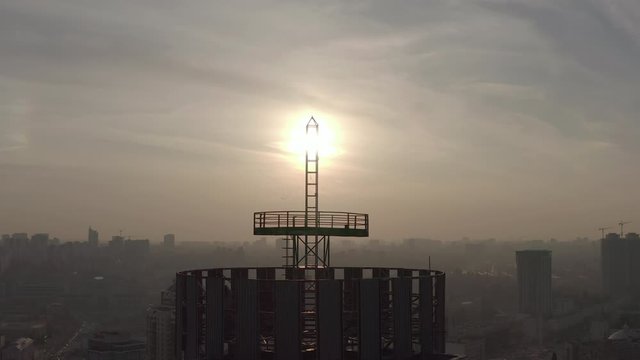 silhouette of a roof spire, lightning rod in a skyscraper. against the backdrop of sunset and evening city center