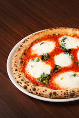 Pizza Margherita with bufala on wooden table. Original Italian recipe. Pizza Margarita with Tomatoes, Basil and Mozzarella Cheese. Close-up.