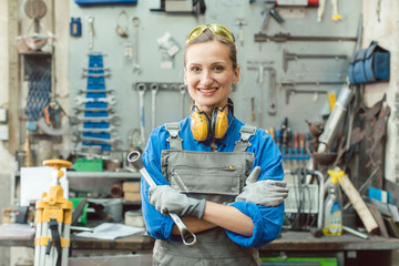Woman metalworker with tool posing for the camera