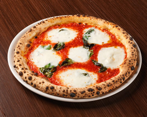 Pizza Margherita with bufala on wooden table. Original Italian recipe. Pizza Margarita with Tomatoes, Basil and Mozzarella Cheese. Close-up.