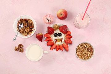 Strawberry smoothie and granola, fresh berries, apples, strawberries and grapes on a pink sunny background. The concept of healthy and natural food. Useful breakfast, food for children,