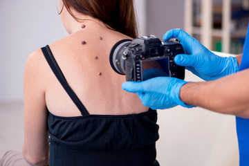 Young woman visiting male doctor dermatologist