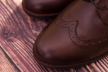 new brown leather shoes with laces on a dark background