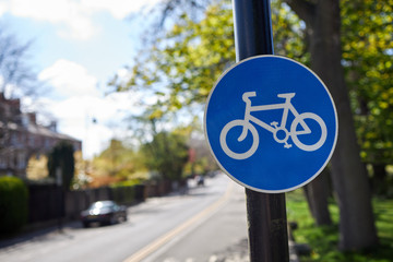 Bike land sign on urban street for cyclists. Trees and blue sky in the background. Space for copy text.