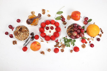 Useful breakfast, food for children, Strawberry yogurt, granola, cottage cheese, honey, mango, strawberries and grapes on a light table. The concept of healthy and natural food. selective focus