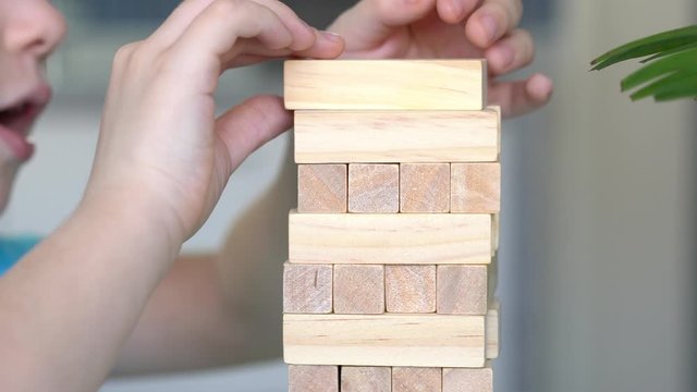 Little boy playing with wooden eco-friendly board game. Concept. Quarantined home games. Indoor