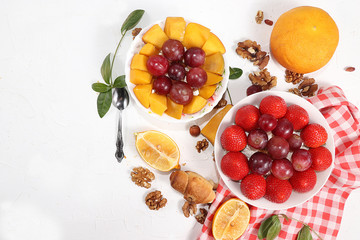 Useful breakfast, food for children, Strawberry yogurt, granola, cottage cheese, mango, strawberries and grapes on a light table. The concept of healthy and natural food. selective focus, top view