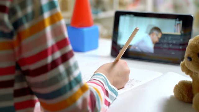 Middle-aged man distance teacher online tutor conferencing on tablet communicate with pupil by webcam video call e-learning. Home quarantine distance learning and working at home.