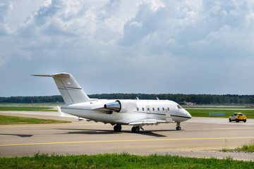 Fototapeta na wymiar Airport follow me car guiding the business jet on the taxiway