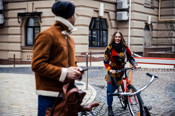 Fototapeta na wymiar Mirthful lady cycling and suddenly meeting her boyfriend