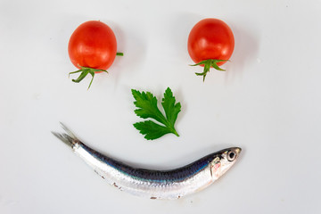 Sardina, pomodori e prezzemolo formano una faccia sorridente