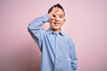 Young little boy kid wearing elegant shirt standing over pink isolated background doing ok gesture with hand smiling, eye looking through fingers with happy face.