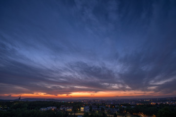 Zachód słońca nad Krakowem . Widok z kopca Krakusa na południu Krakowa. Błękitne i pomarańczowe niebo z chmurami.