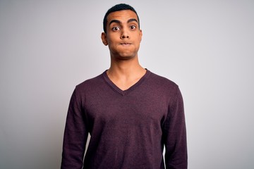 Young handsome african american man wearing casual sweater over white background puffing cheeks with funny face. Mouth inflated with air, crazy expression.