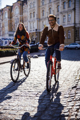 Obraz premium Gladsome cyclers on sunny day in the city stock photo