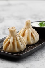 Georgian authentic cuisine. KHINKALI with sour cream. Best for promotion. Marble table.  Close-up and top view. Flat lay