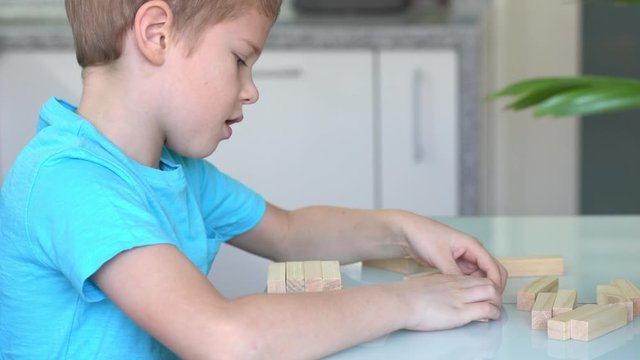 Little boy playing with wooden eco-friendly board game. Concept. Quarantined home games. Indoor