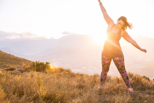 Plus-Size-Model doing sports in the countryside at sunset